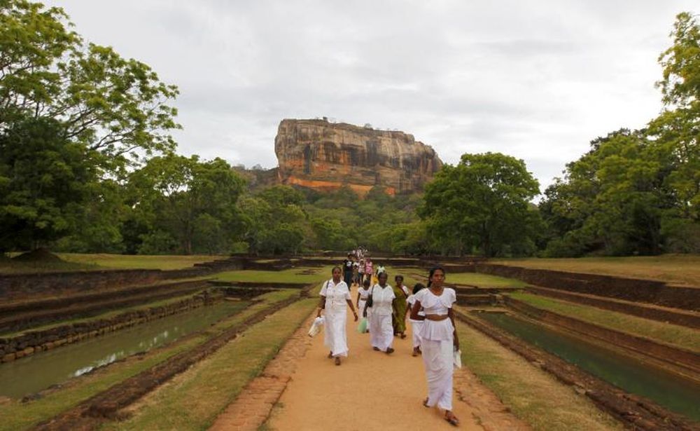 Women leave Sigiriya, an ancient rock fortress and palace ruin, in Matale District