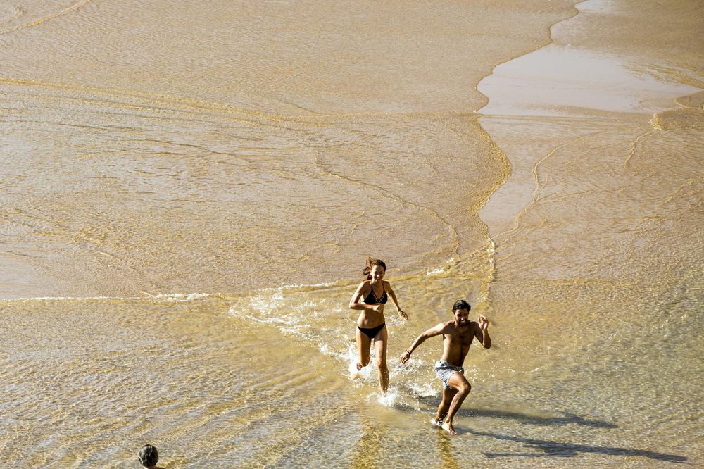 Banhistas que se queixam da água fria na praia do  Algarve