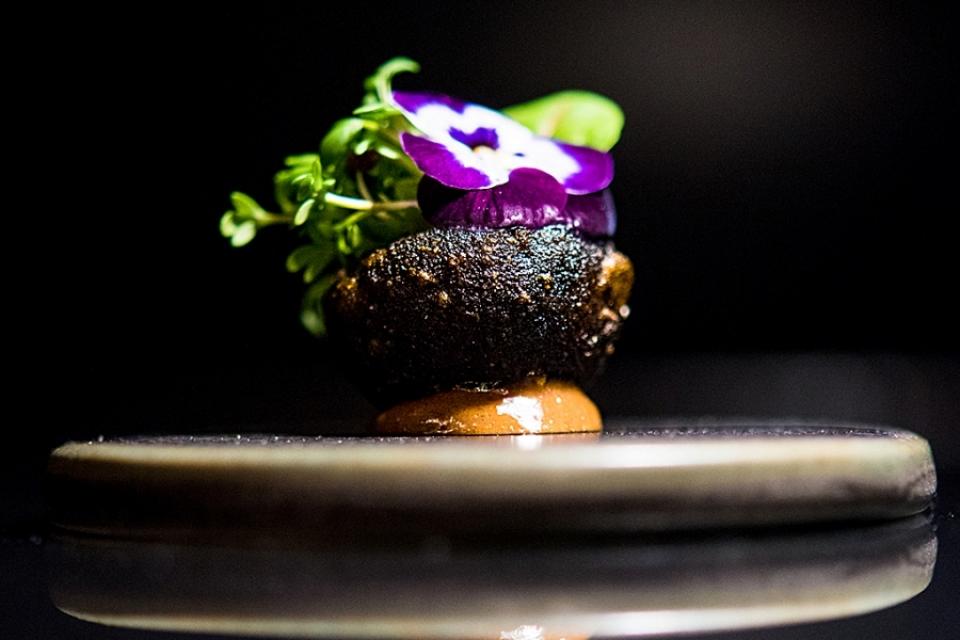 Batata com alho negro, um florido canteiro de sabor intenso, no capítulo de snacks do menu Terra, do Feitoria (Gonçalo Villaverde/GI)