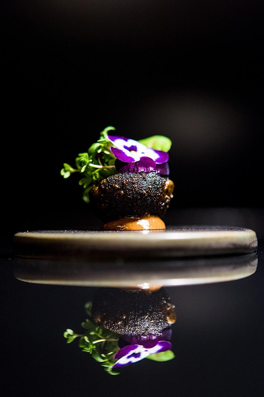 Batata com alho negro, um florido canteiro de sabor intenso, no capítulo de snacks do menu Terra, do Feitoria (Gonçalo Villaverde/GI)
